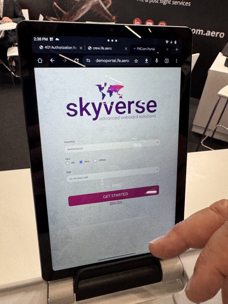 SkyVerse being displayed on a tablet at AIX. This screen asks for the passenger's country and age.