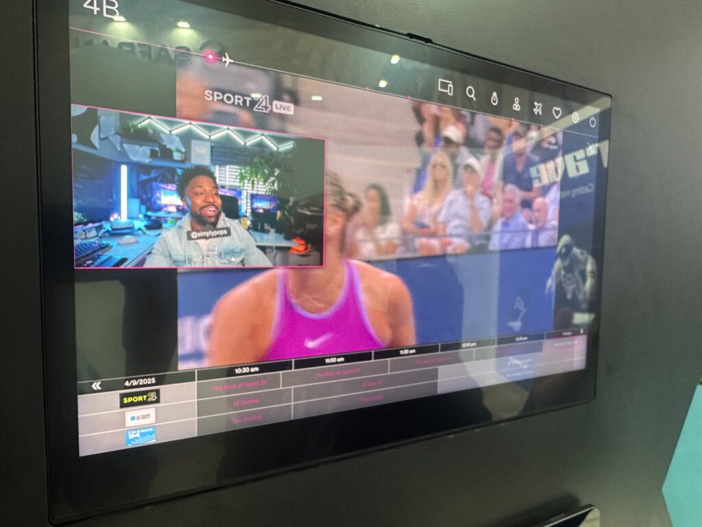 PIP demo with picture in picture being shown on the large IFE screen, on Safran Passenger Innovations' stand at AIX 2025. The firm's new casting solution enables PIP including with the passenger's own PED device content. Here the passenger is viewing a Sport24 channel, whilst watching a show cast from his own device.
