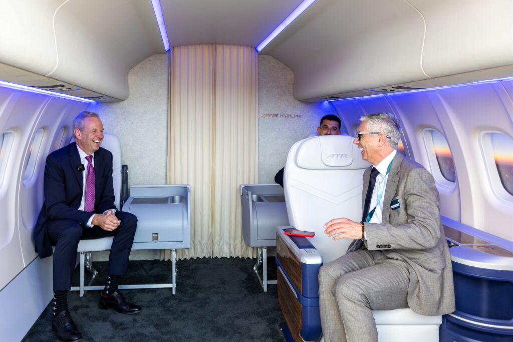 ATR and JSX executives sit in an ATR mockup at the Paris Air Show. The mockup features some of the HighLine interiors that will be installed for JSX.