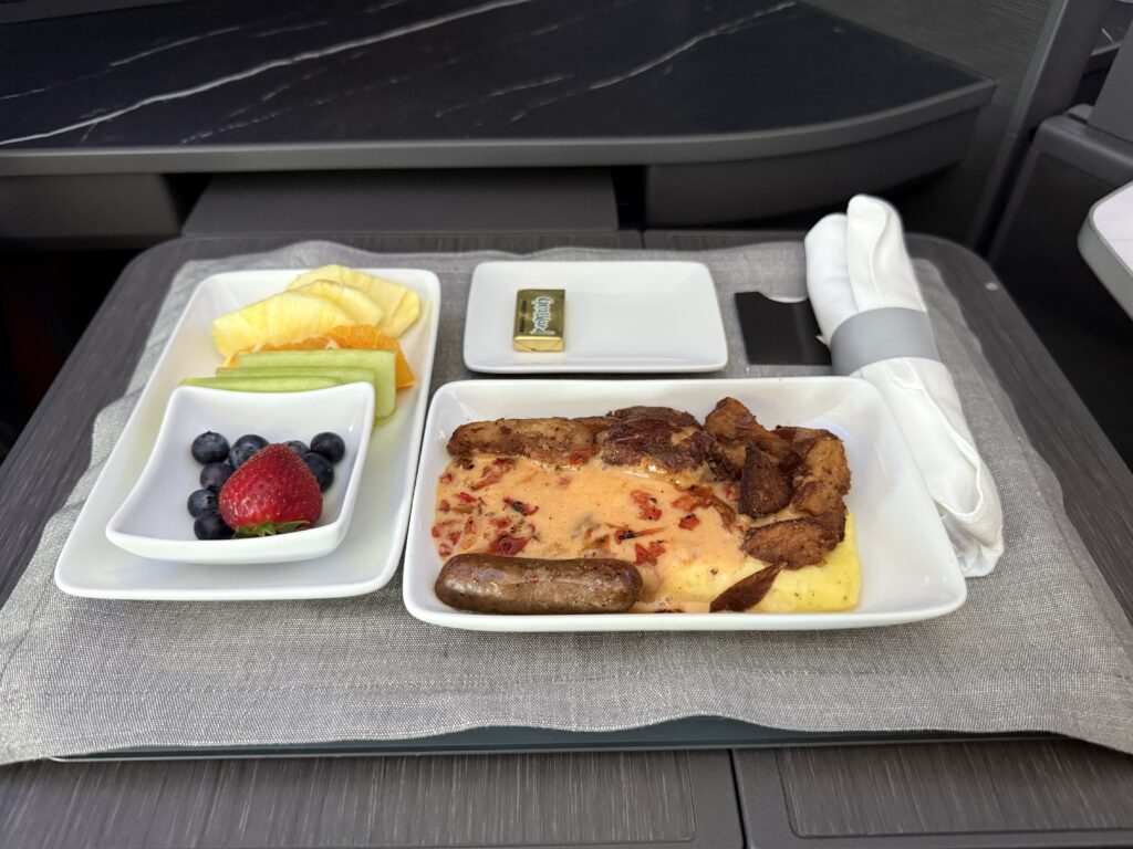A Monterey Jack cheese omelette with chicken sausage, potatoes, and fruit