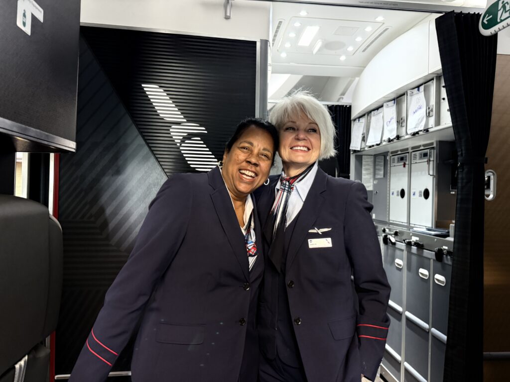 Two American Airlines flight attendants welcome passengers