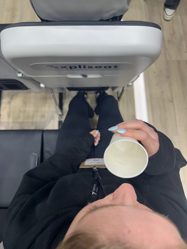 Looking down on a passenger that is sitting in the aircraft seat showing the proximity to the seat in front of them 