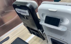 Close up of the Expliseat seat and PED holder on the AIX show floor. The word Expliseat is on the seatback of one of the seats.