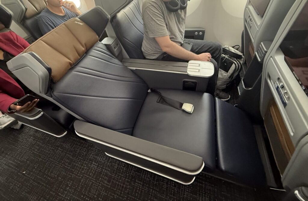 Premium Economy seat in full recline mode, showing great leg support from calf rest.