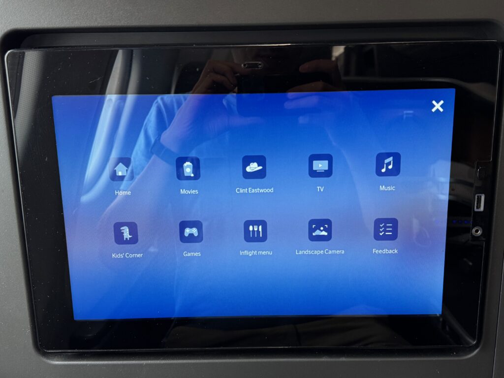 Close up of IFE screen with a variety of options, including, notably, a Clint Eastwood channel.