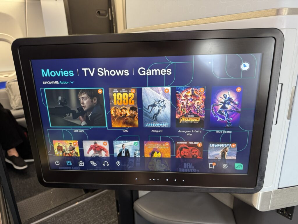 IFE screen is displaying various content options to the passenger