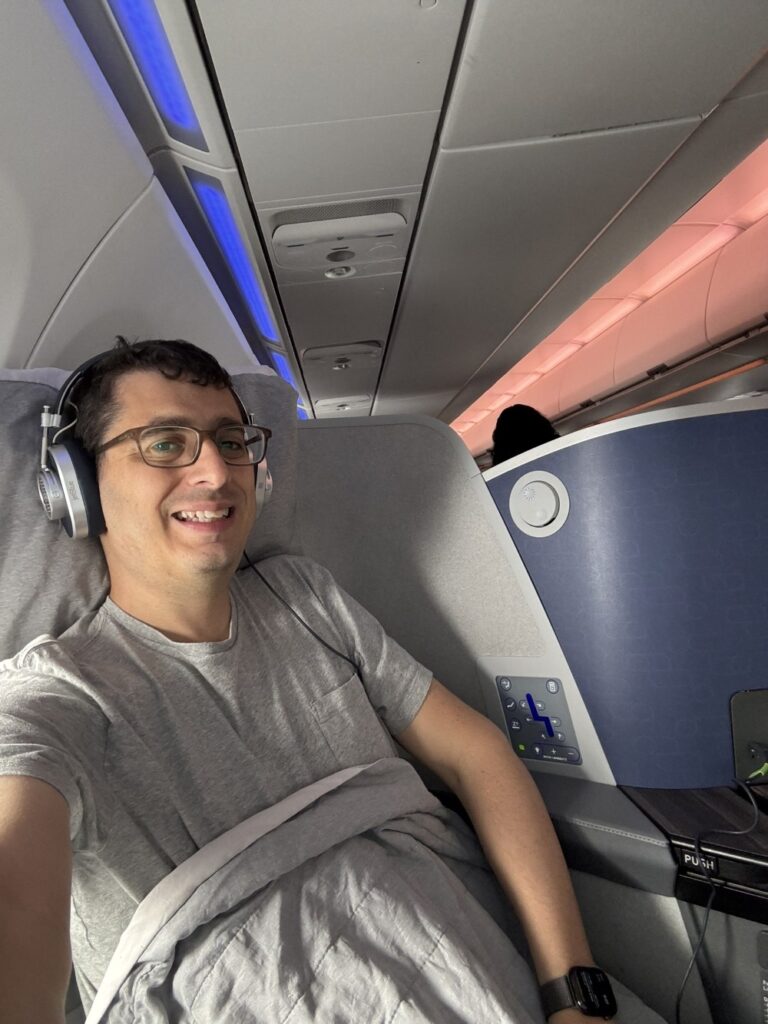 The author is sitting in the seat with headphones on