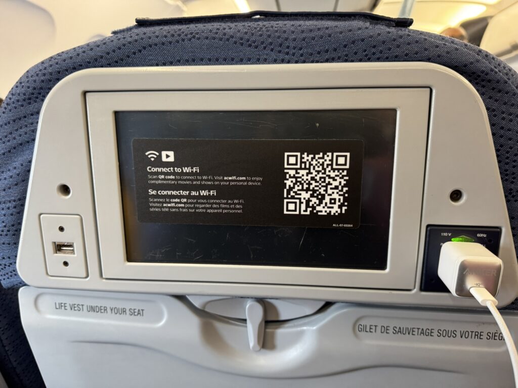 A close up of the IFE screen on the Air Canada A320 with the sticker covering the screen.