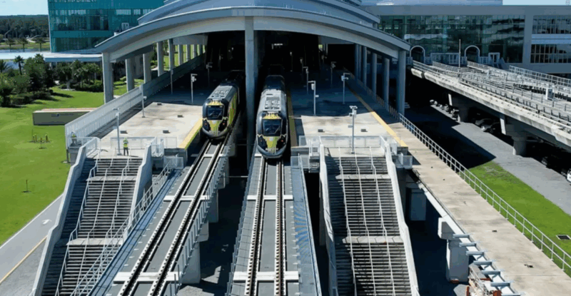 Two Brightline trains are exiting the station