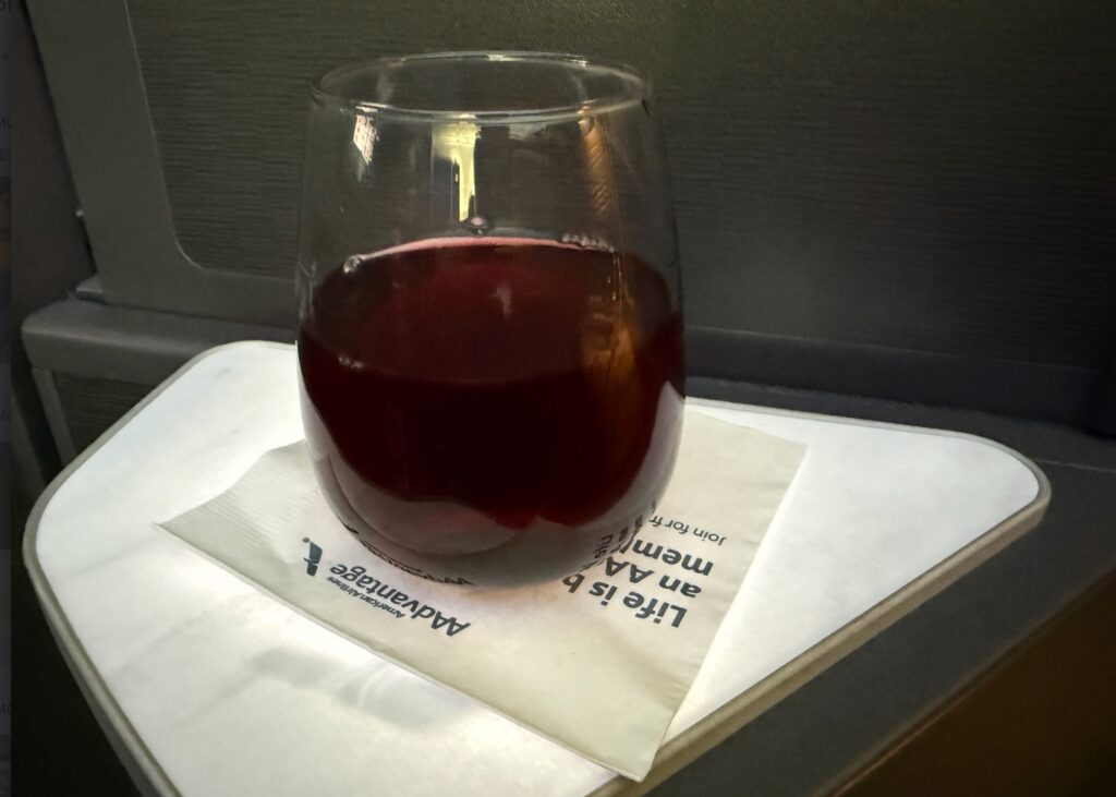 Glass of red sits on the white drinks table.