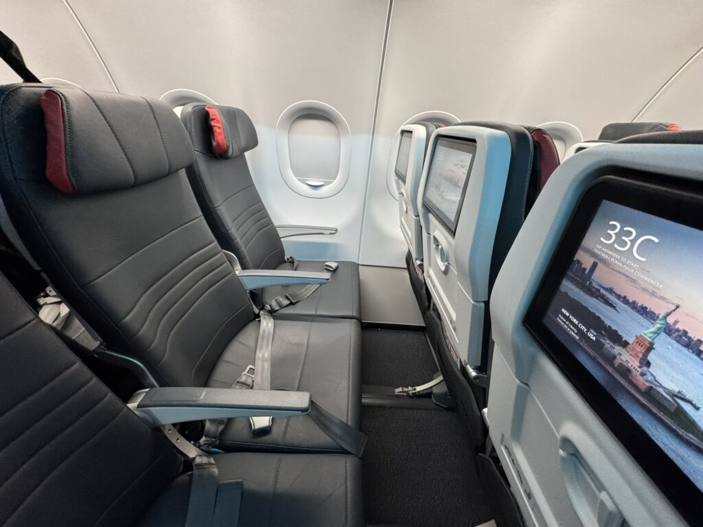 The new Air Canada slimline seats are clad in a charcoal-like color with red accents on the headrests. 