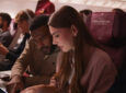 A woman uses Starlink IFC in-flight on a Qatar Airways widebody.