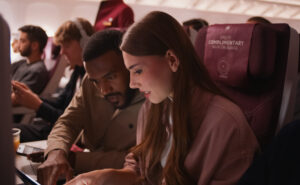 A woman uses Starlink IFC in-flight on a Qatar Airways widebody.