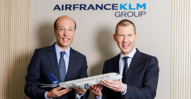 Air France-KLM and SAS executives posing for a photo with an aircraft model in celebration of the acquisition.