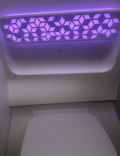 A geometric light patten illuminates the aircraft lavatory.