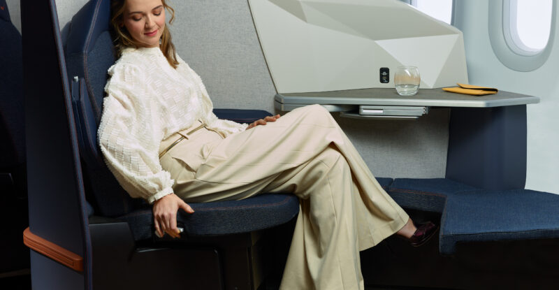 A female passenger is sitting in the Stelia OPERA ESSENTIAL seat