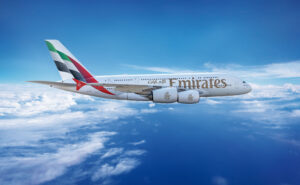 Emirates retrofitted A380 in flight on a clear blue-sky day.