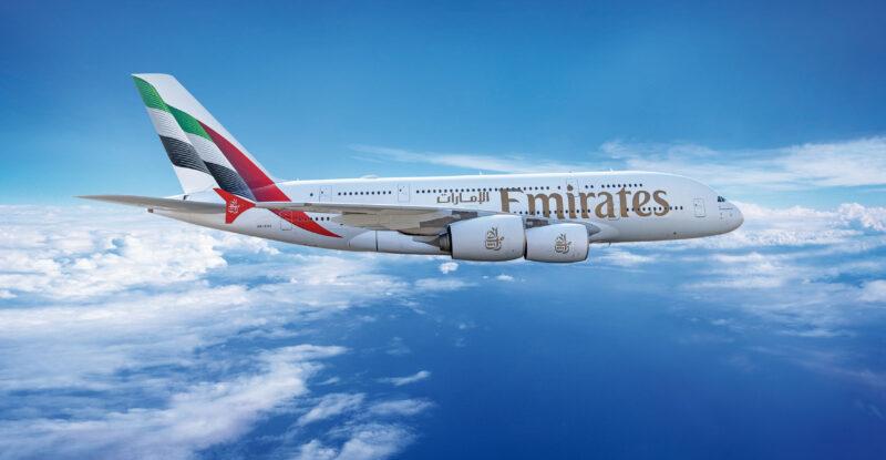 Emirates retrofitted A380 in flight on a clear blue-sky day.