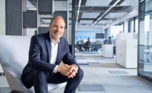 Lars Wagner is sitting on a chair in the Airbus offices for a photo.