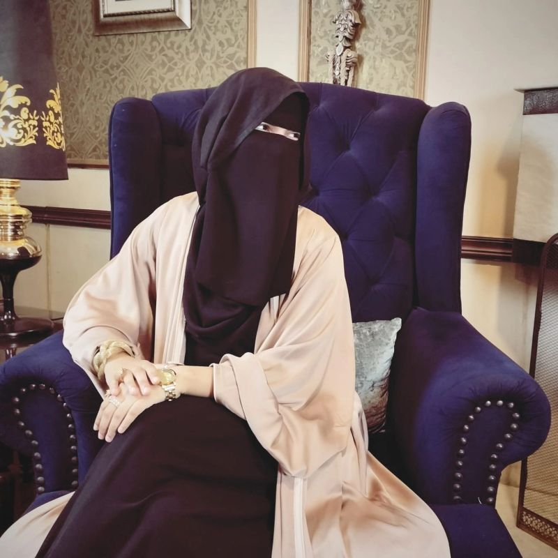 Captain Qadar Sarfraz sitting in a blue chair