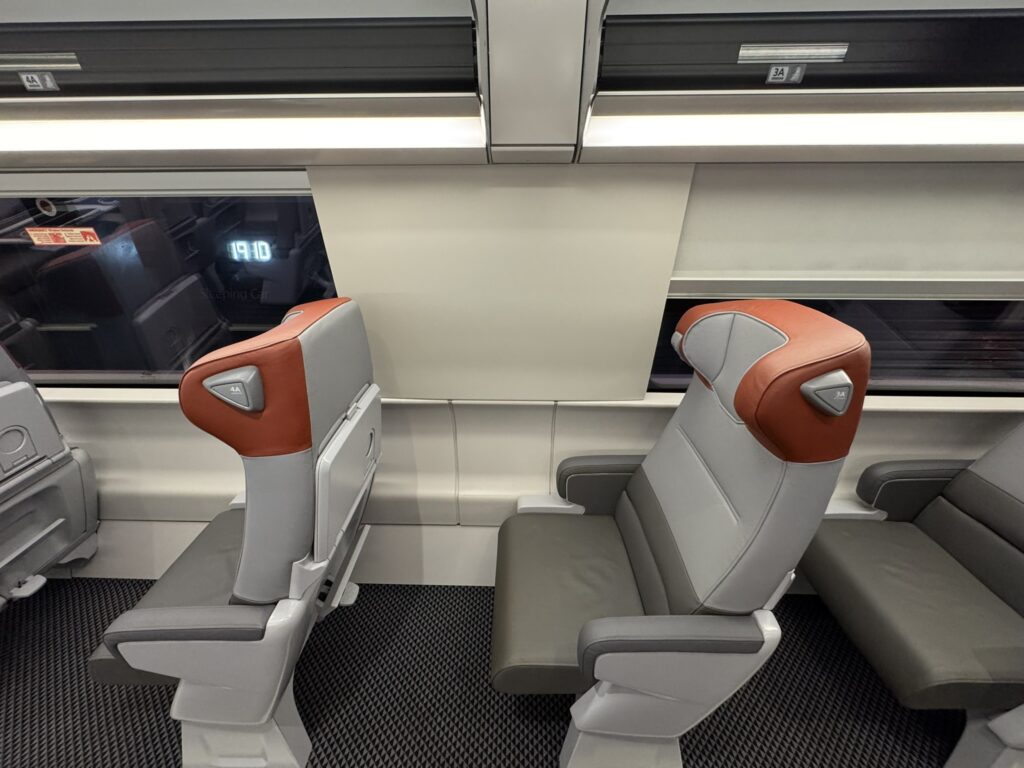 First class seats with orange headrests. 