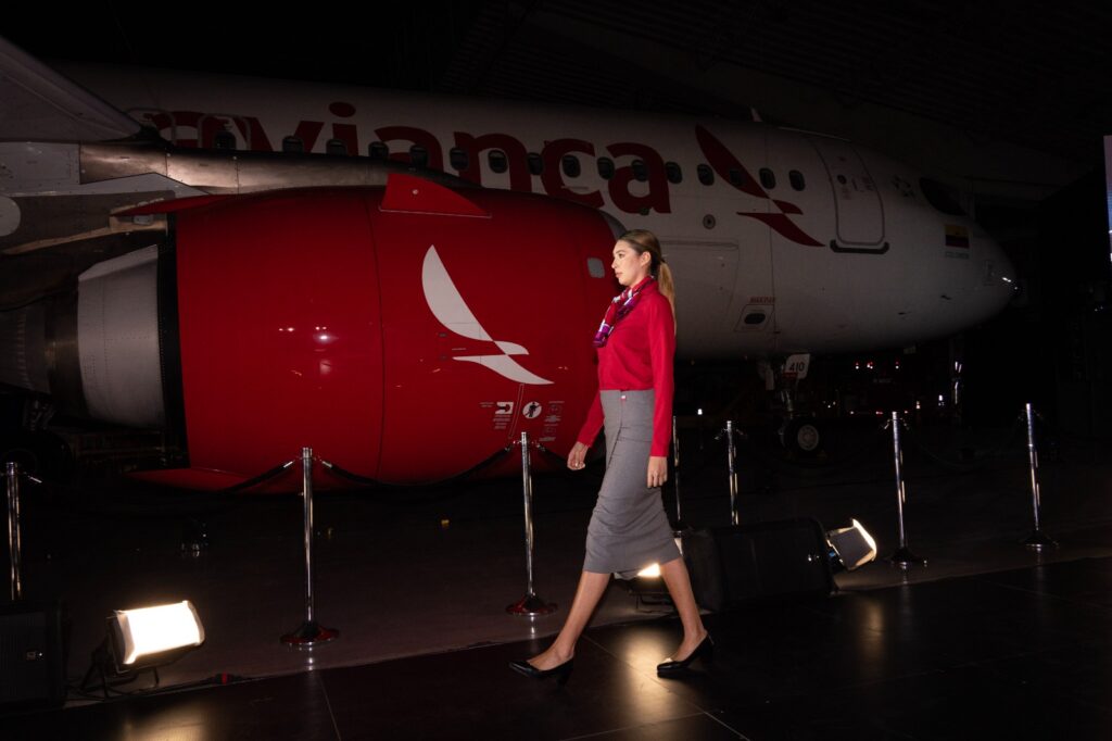 A fashion runway in front of an Avianca aircraft. Models are wearing the new uniforms for crew.