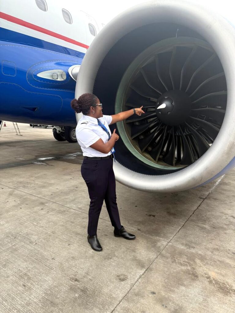 Captain Ibironke Rotimi-Olajide pointing to the aircraft engine.