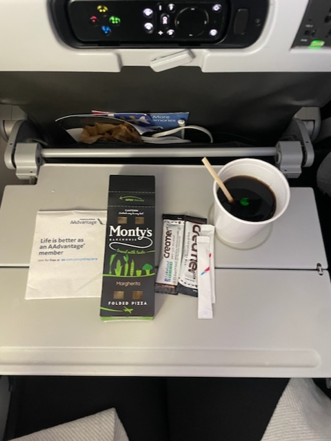 A cup of coffee and a slice of pizza for breakfast just before landing.