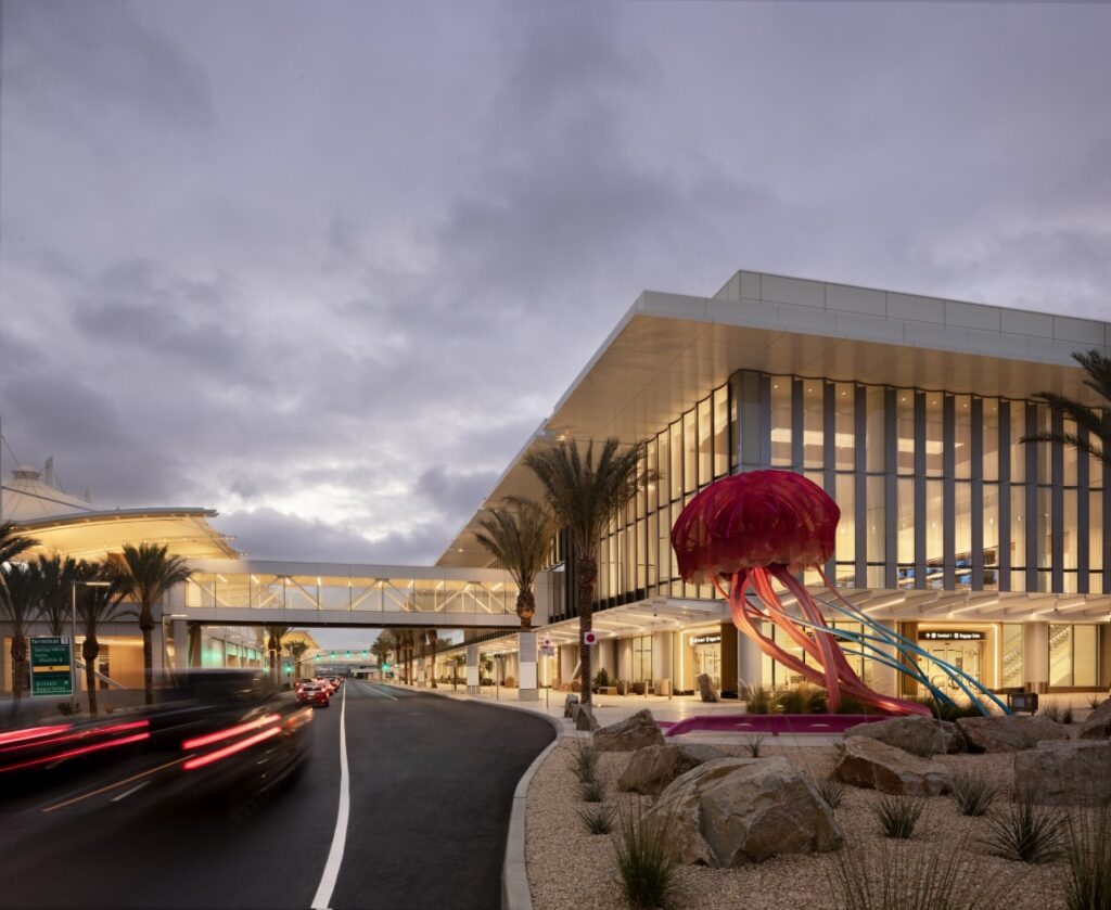 Outside facade of San Diego International Airport Terminal 1 arrivals building, featuring lots of glass and artwork.