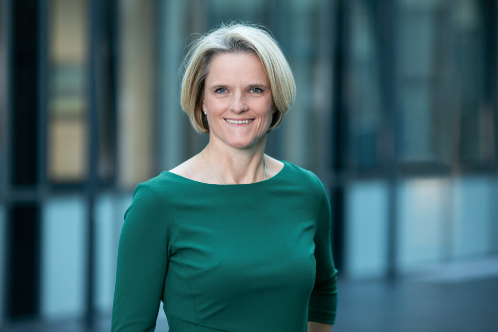 Nicole Dreyer-Langlet smiling for a photo in a green long sleeve shirt