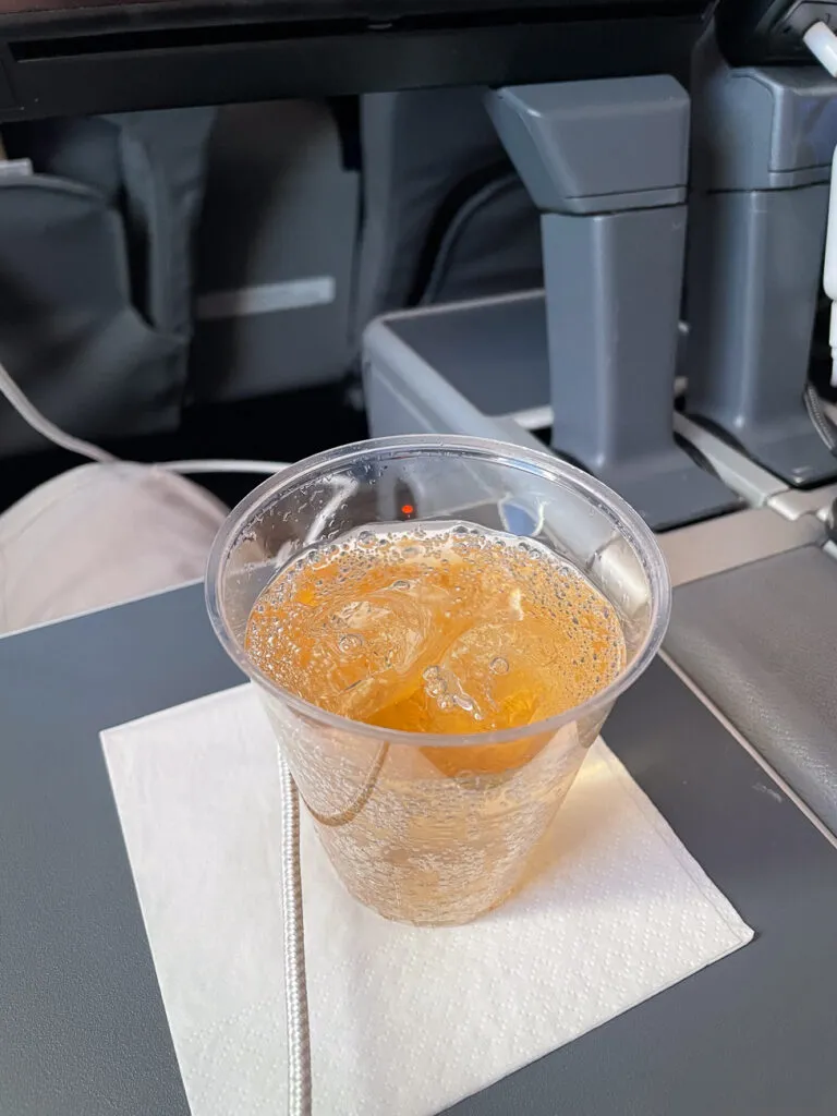 A beverage sits on the aircraft tray table.