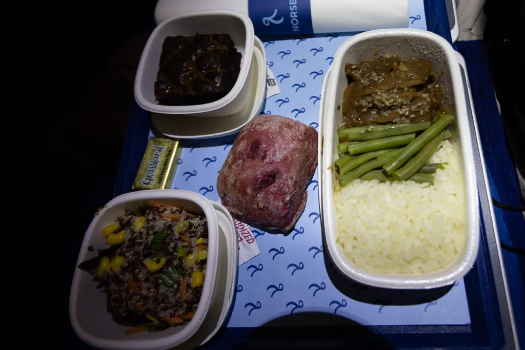 Beef stroganoff meal set out on the aircraft tray table. 