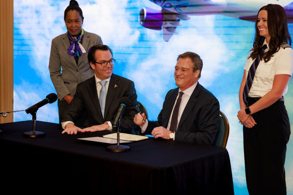 Embraer and Avelo execs sign the agreement.