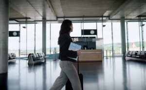 A passenger is carrying a copy of SWISS Magazine through the airport.