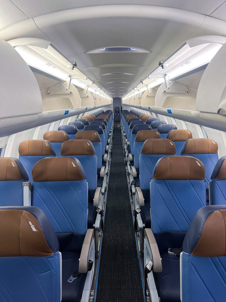 American Airlines Bombardier CRJ900 cabin interior with blue seats and brown headrests.