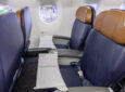 Side view of American Airlines' E175 seats; they are blue with rich brown headrests.