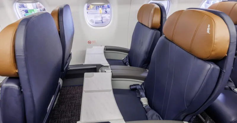 Side view of American Airlines' E175 seats; they are blue with rich brown headrests.