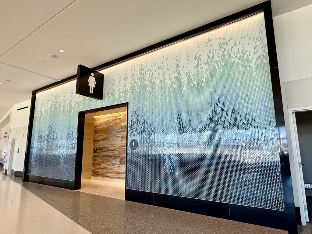 A beautiful blue mosaic surrounds the restroom.