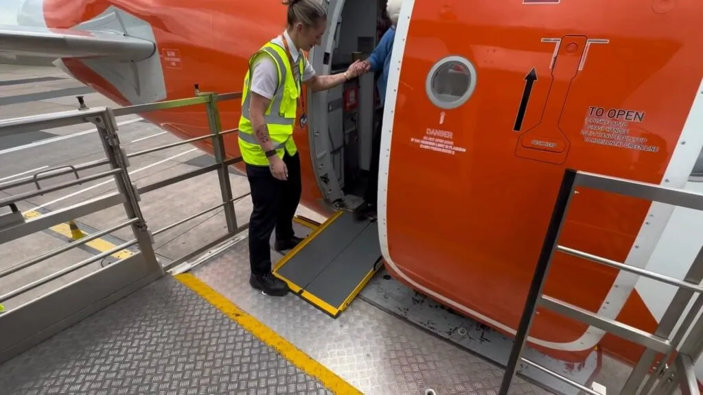 A Portaramp ramp is positioned between the aircraft and the jet bridge to ensure an easier boarding experience for the Disabled passenger