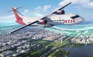 Rendering of ATR turboprop in flight over a city.
