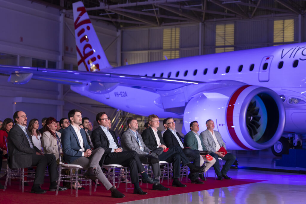 Executives sit in front of the Virgin Australia E190-E2 as it is unveiled.