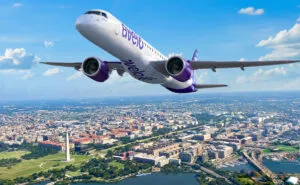 Rendering of E2 in Avelo livery flying over a town and a body of water