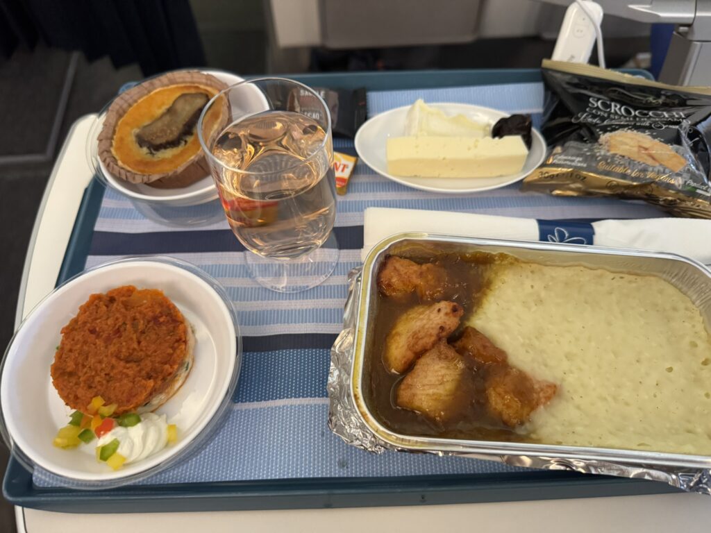 A meal of chicken in Colombo sauce and mashed potatoes is set out on the aircraft table. 