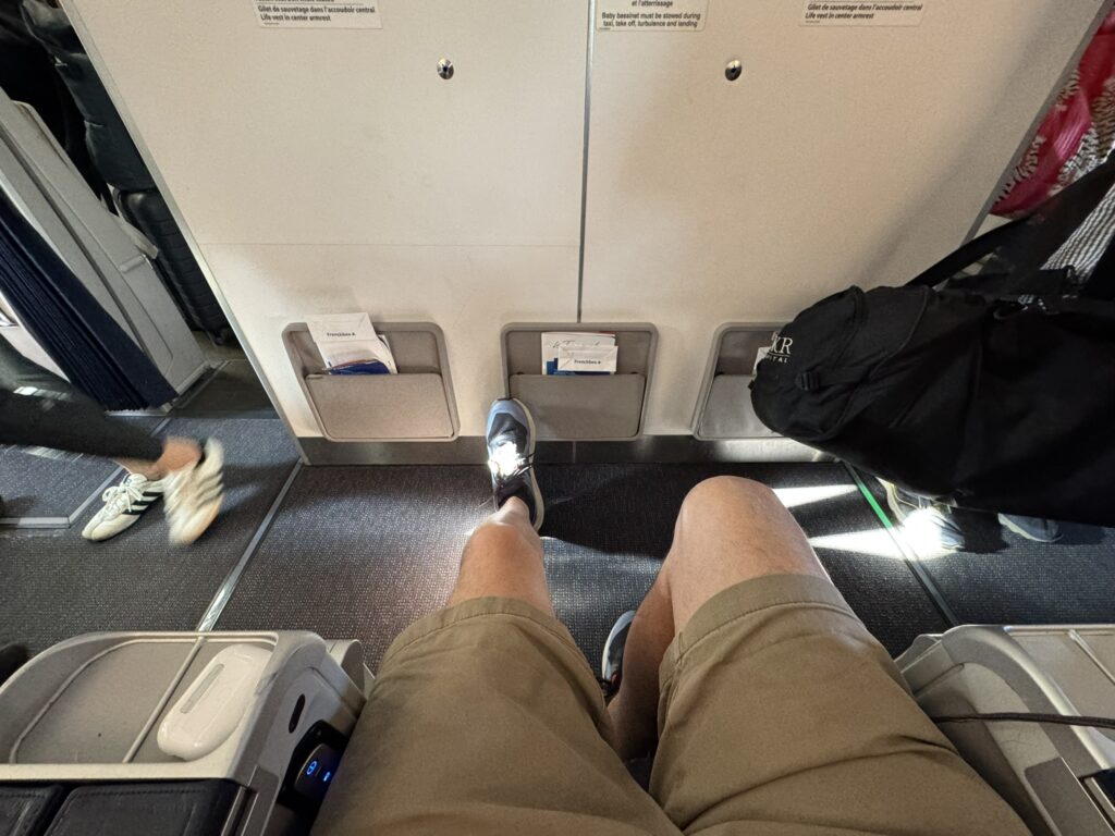 The author's knees are showing plenty of legroom in this bulkhead seat