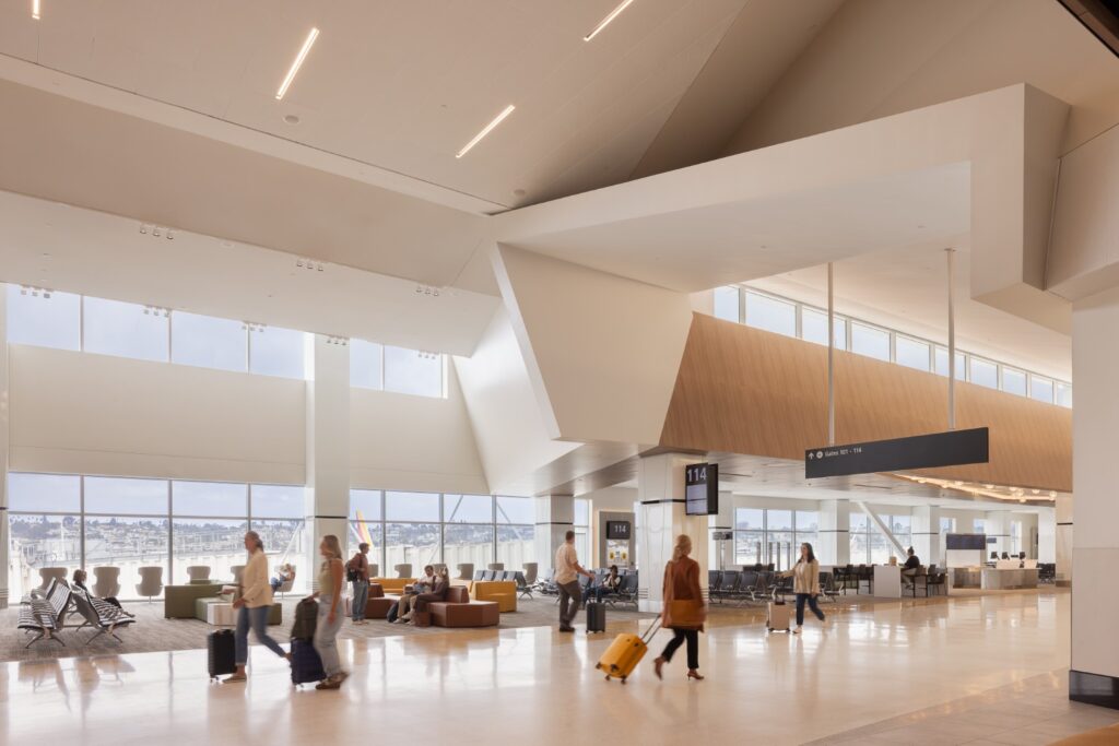 San Diego International Airport gate hold seating . A large open space with lots of natural light and various seating options.