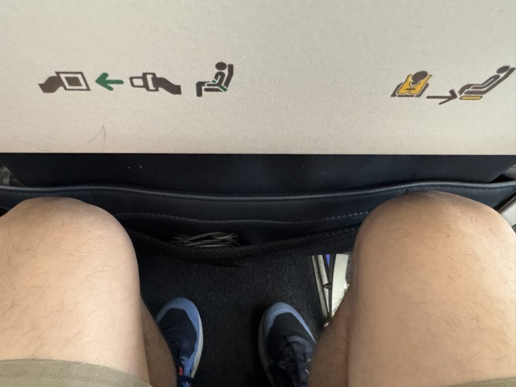 A passenger's knees are right up against the seat in front of them.