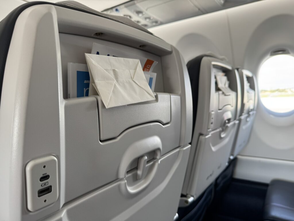 The seat is equipped with both USB-A and high powered 60W USB-C ports, with a personal device holder, as pictured.