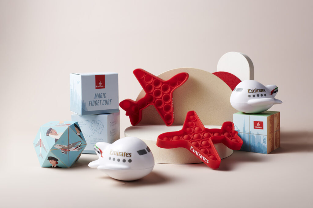 Emirates' new sensory products and fidget toys for children and adults. Some toys include a red plane shaped pop-it and toy planes.