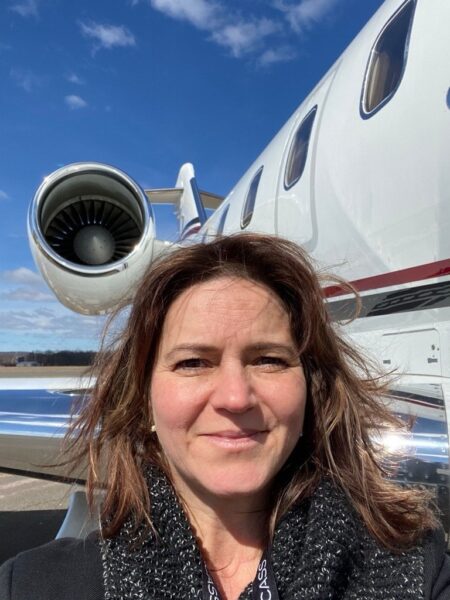 Denise Buklis taking a selfie in front of a bizjet.