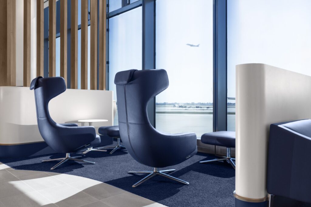 Capsule chairs look out the large windows in the lounge facing the runway of Chicago Airport.